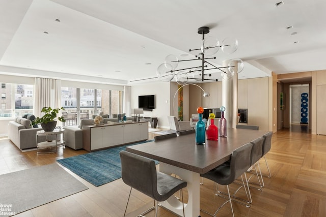 dining space featuring light parquet flooring and a chandelier