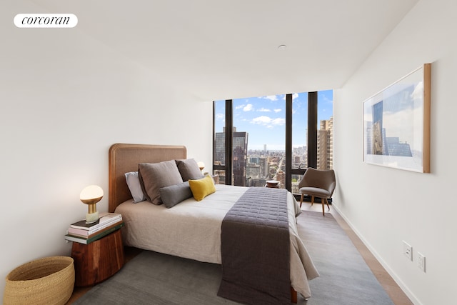 bedroom with baseboards and a view of city