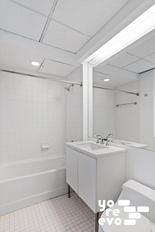 full bathroom with vanity, tiled shower / bath combo, and toilet