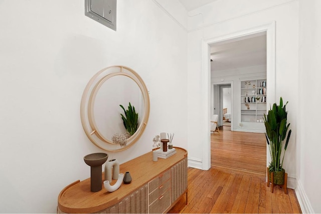 corridor featuring light wood-style flooring and baseboards