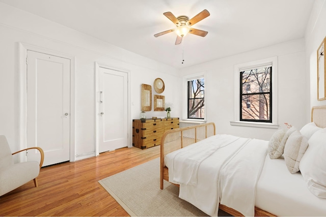 bedroom with light wood-style floors and a ceiling fan