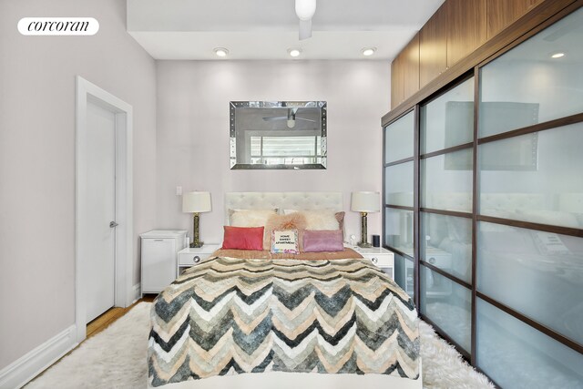 bedroom with ceiling fan, a closet, and light hardwood / wood-style flooring