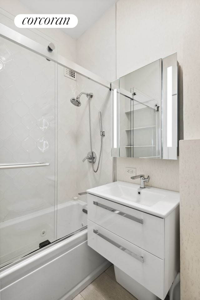 bathroom with vanity and bath / shower combo with glass door