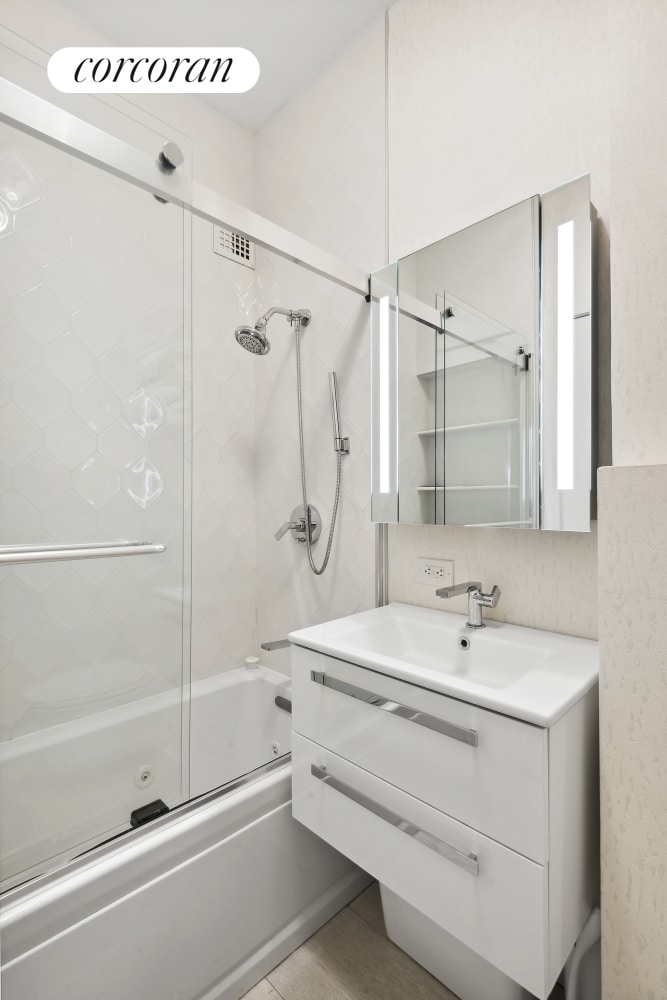bathroom with vanity and enclosed tub / shower combo