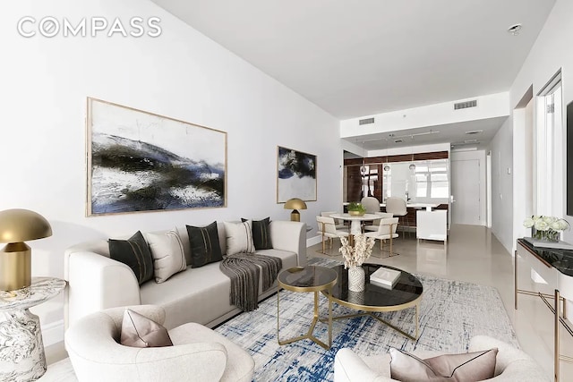 living room featuring visible vents, finished concrete flooring, and baseboards