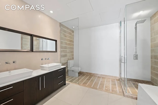 111 Fulton St Unit Ph103, New York City, NY 10038 - bathroom with double vanity, a shower stall, toilet, tile walls, and tile patterned flooring