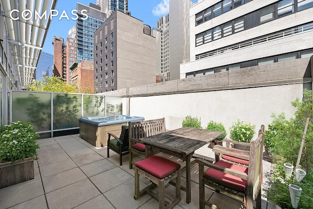 111 Fulton St Unit Ph103, New York City, NY 10038 - view of patio featuring a hot tub, a city view, and outdoor dining area