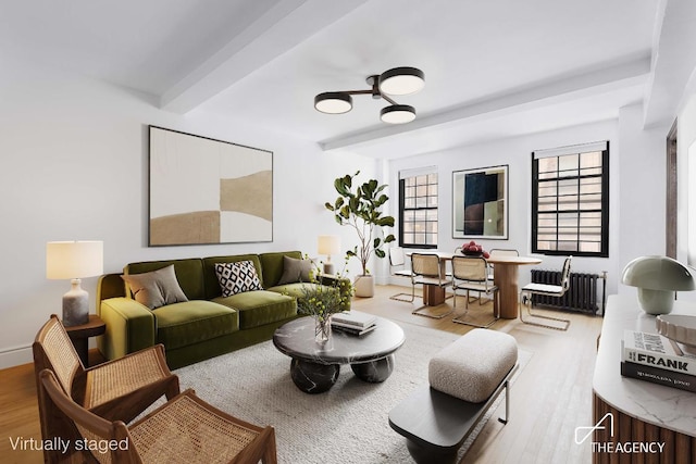 living room featuring radiator, beam ceiling, and light hardwood / wood-style floors