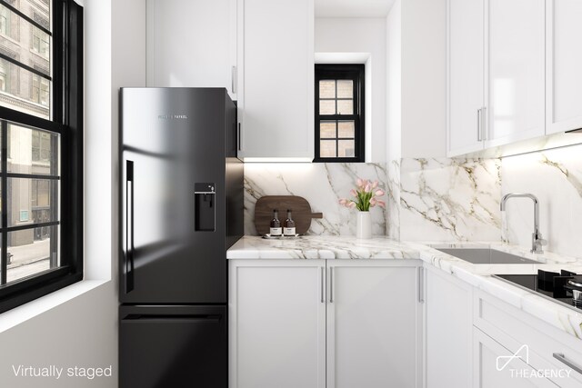 kitchen with white cabinetry, backsplash, sink, and black appliances