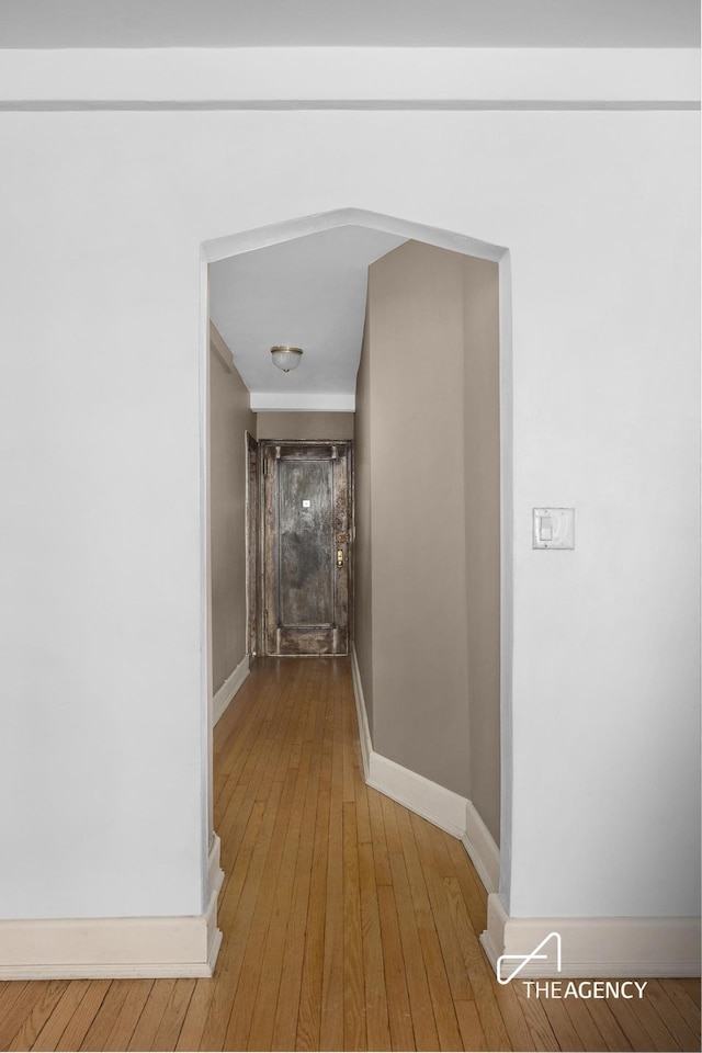 hallway with wood-type flooring and baseboards