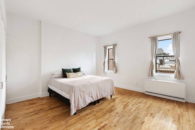 bedroom featuring radiator heating unit and light hardwood / wood-style flooring