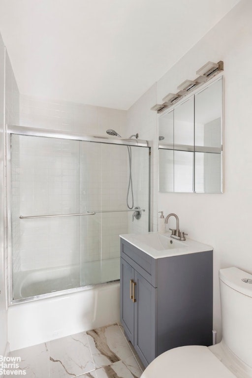 full bathroom with vanity, enclosed tub / shower combo, and toilet