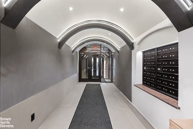 hallway featuring lofted ceiling and a mail area