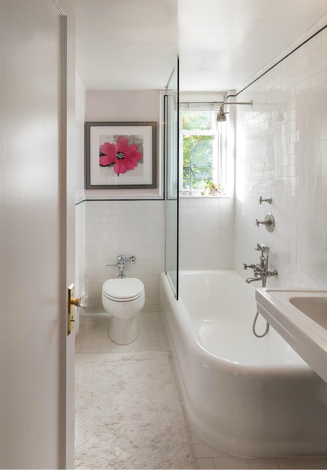 bathroom with toilet, tile walls, shower / tub combination, and tile patterned flooring