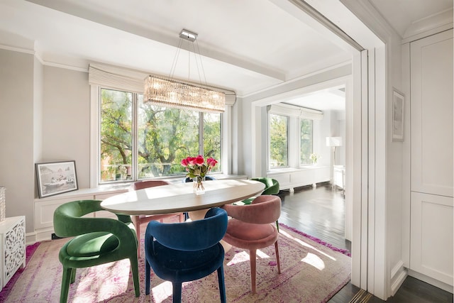 dining area with an inviting chandelier, wood finished floors, and crown molding