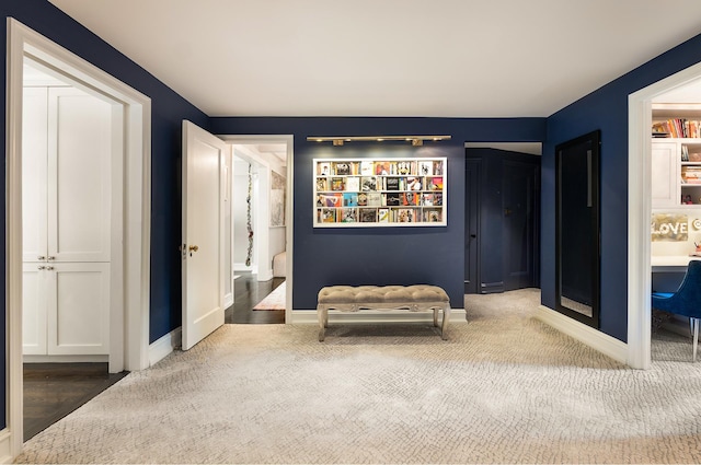 living area featuring carpet and baseboards