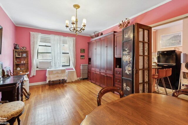 home office featuring ornamental molding, radiator, an inviting chandelier, and light hardwood / wood-style floors