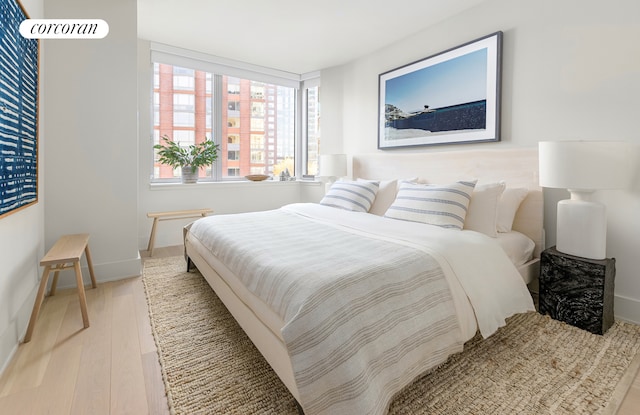 bedroom with light wood finished floors and baseboards