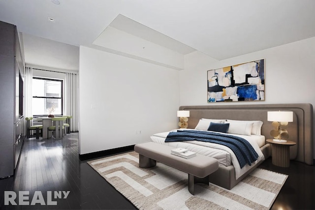 bedroom featuring baseboards and wood finished floors