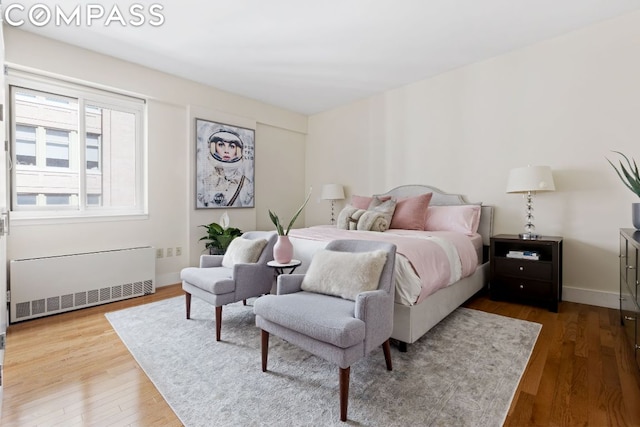 bedroom with hardwood / wood-style flooring and radiator heating unit