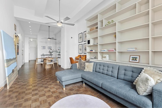 living room featuring a high ceiling, ceiling fan, and dark parquet floors