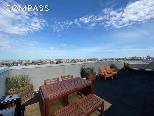 view of patio featuring outdoor dining space, a view of city, and a balcony