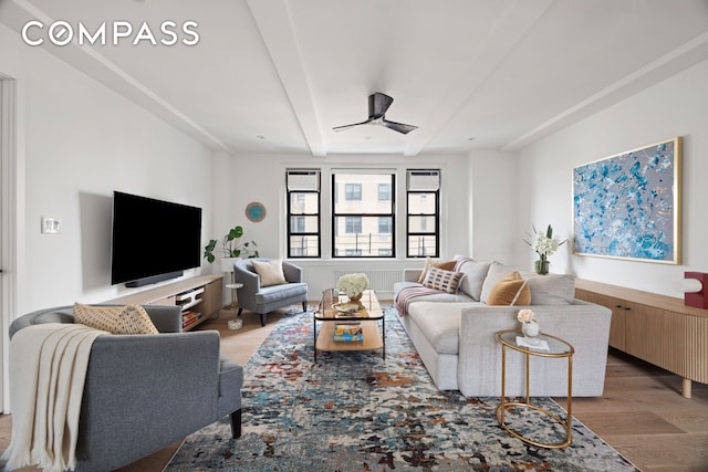 living room featuring beamed ceiling and light wood-style floors