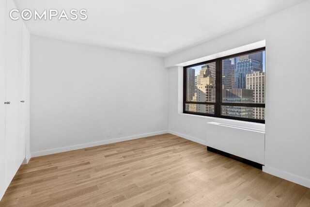 unfurnished room with light wood-type flooring