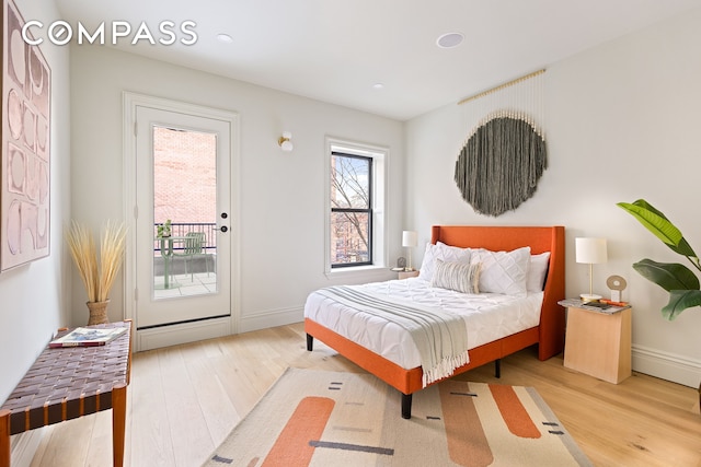 bedroom featuring access to outside, wood finished floors, and baseboards