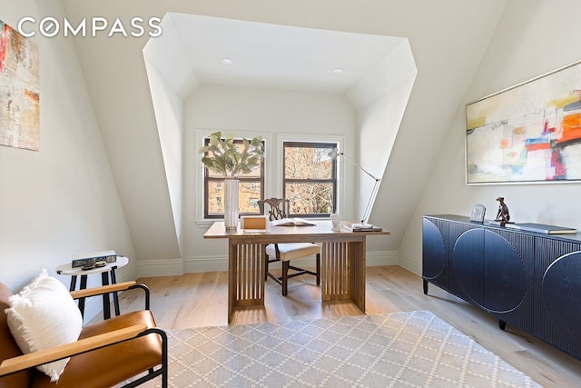 office space with lofted ceiling, light wood finished floors, and baseboards