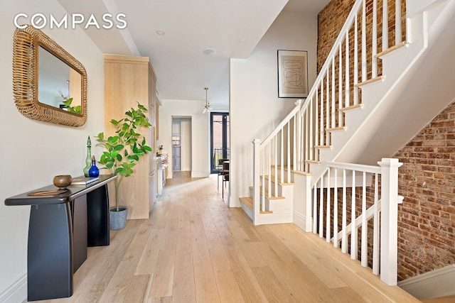 entrance foyer with stairs, light wood finished floors, and baseboards