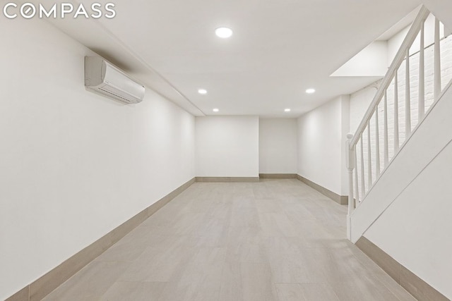 basement with light hardwood / wood-style floors and an AC wall unit