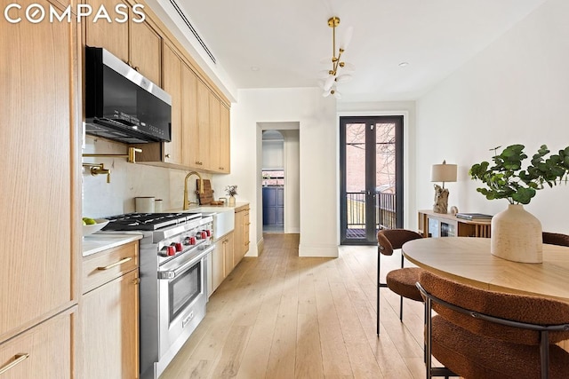 kitchen with light hardwood / wood-style flooring, light brown cabinets, french doors, and appliances with stainless steel finishes