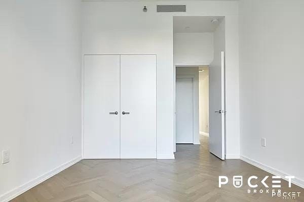 unfurnished bedroom with a closet, visible vents, and baseboards