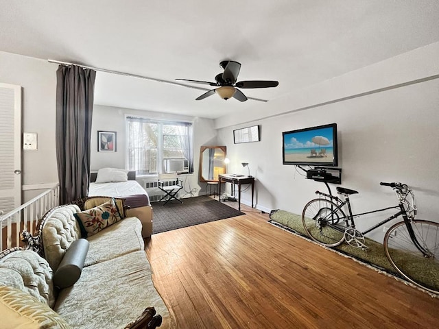 living room featuring radiator heating unit, wood-type flooring, cooling unit, and ceiling fan