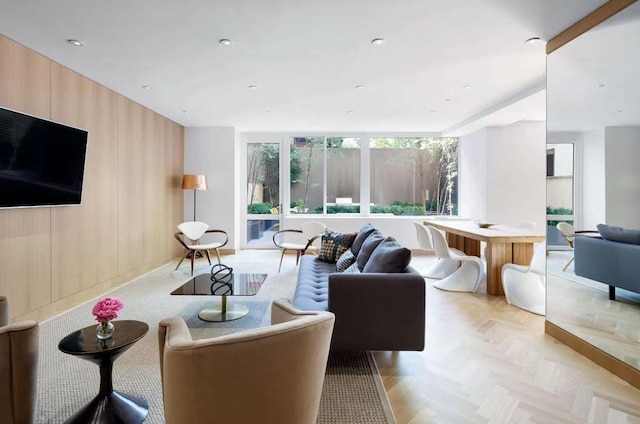 living room featuring wooden walls and light parquet floors