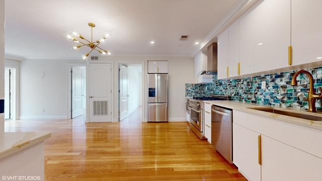 423 Greenwood Ave Unit 3A, New York City, NY 11218 - kitchen with visible vents, ornamental molding, wall chimney exhaust hood, stainless steel appliances, and a sink