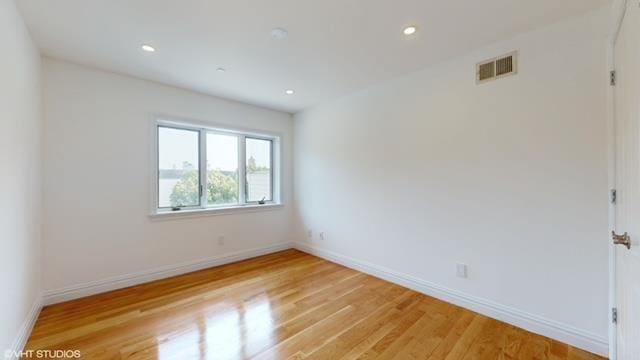 empty room with light wood-style floors, baseboards, visible vents, and recessed lighting