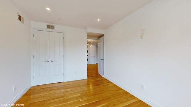 unfurnished bedroom featuring a closet, recessed lighting, visible vents, and light wood-style floors