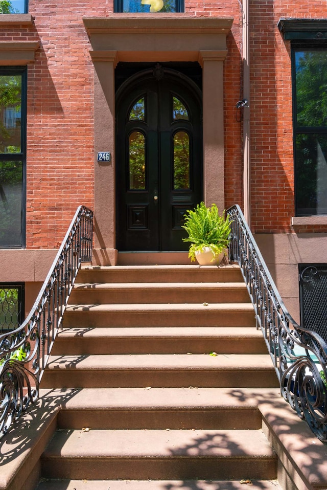 entrance to property featuring french doors and brick siding