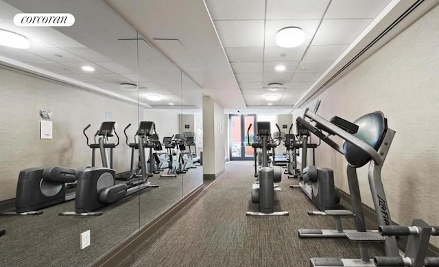 workout area featuring visible vents, baseboards, and a drop ceiling