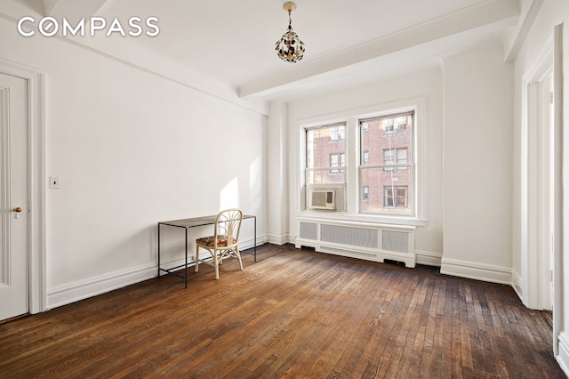 empty room featuring radiator, dark wood-style flooring, cooling unit, baseboards, and a notable chandelier