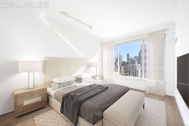 bedroom with crown molding and light wood-type flooring