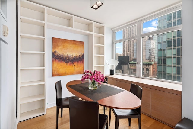 dining space featuring built in features and light wood finished floors
