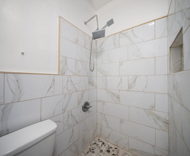 bathroom with toilet and a tile shower