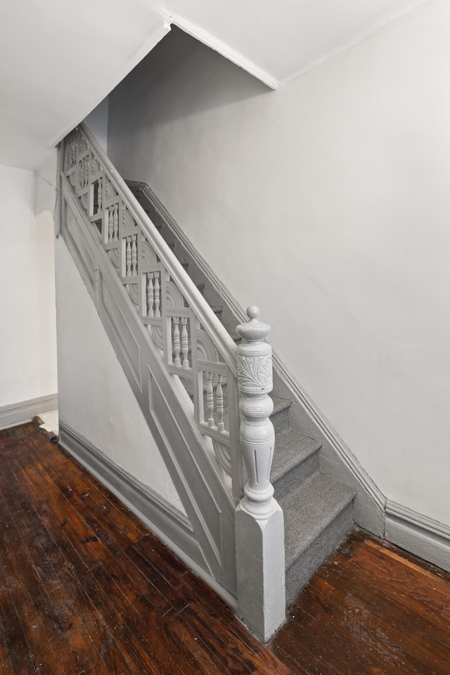 staircase featuring hardwood / wood-style flooring and baseboards