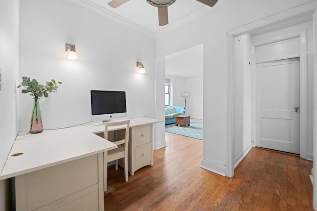 home office with dark wood-type flooring, crown molding, baseboards, and a ceiling fan