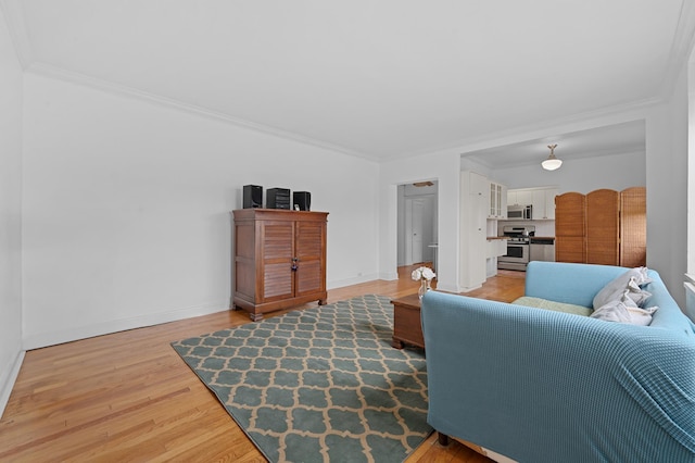 living room featuring crown molding, baseboards, and light wood-style floors