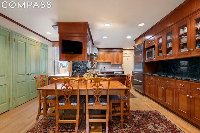 dining room with crown molding and light hardwood / wood-style flooring