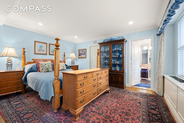 bedroom featuring dark wood-style flooring, ornamental molding, multiple windows, recessed lighting, and ensuite bathroom